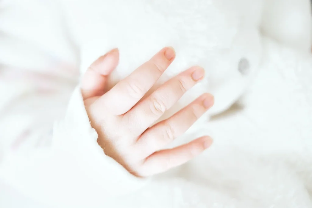 Photographie d'une main de bébé sur son doudou