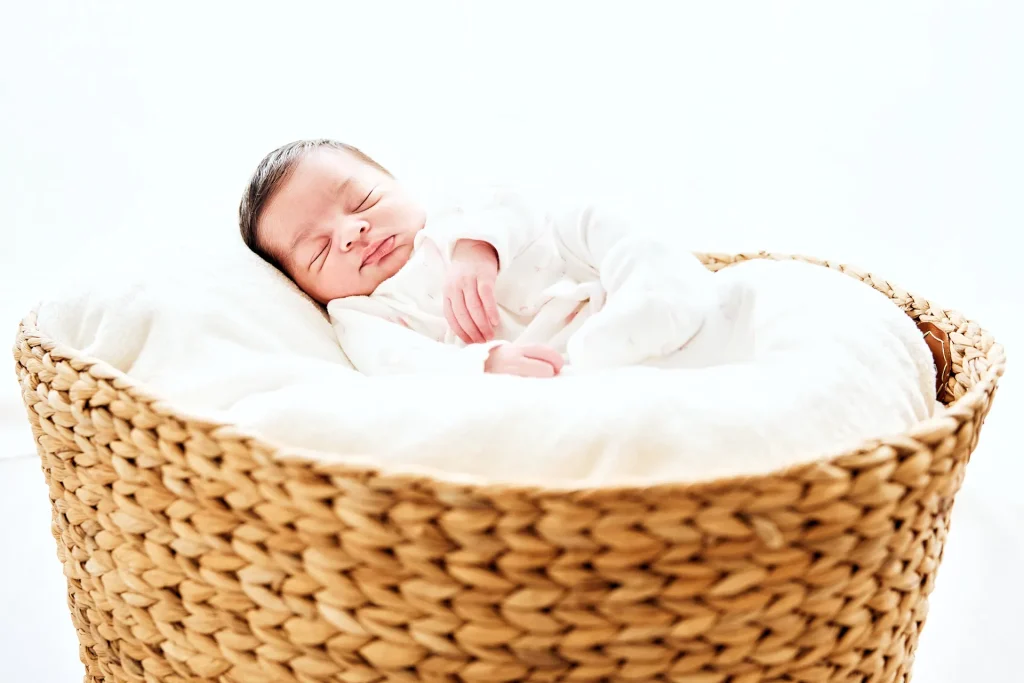 Photographie de bébé endormi dans un panier