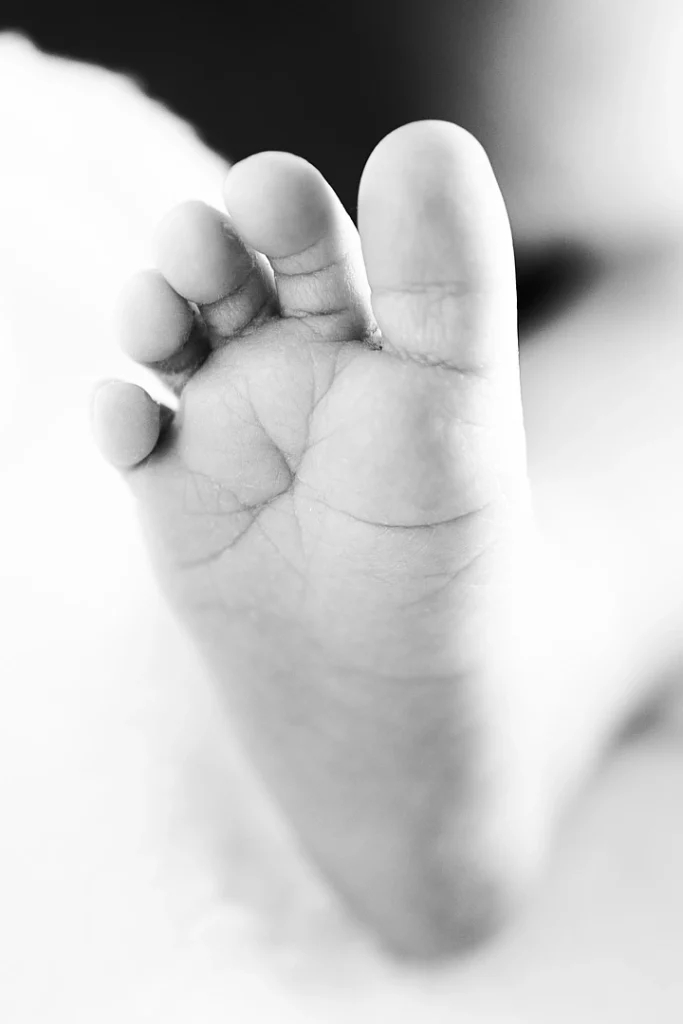 Photographie en noir et blanc d'un pied de bébé