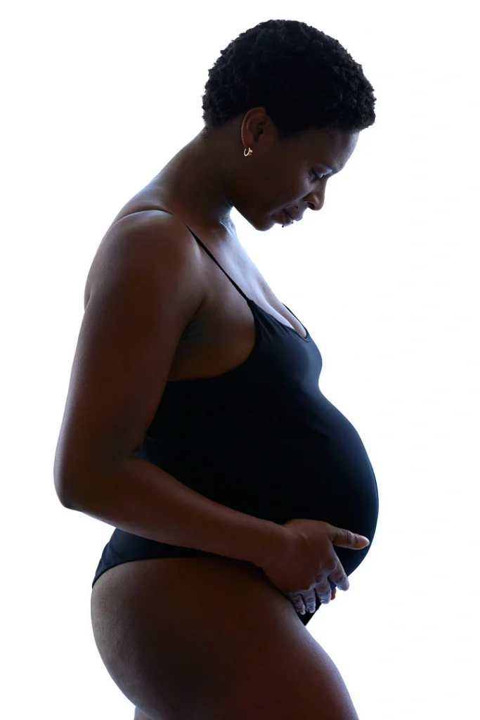 Séance photo de grossesse avec une femme enceinte à contre jour